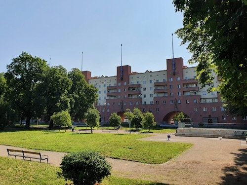 Green courtyard and red-brick communal housing building in Vienna