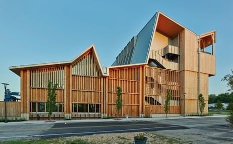 Contemporary multi-story timber building with angular roofs and wood façades