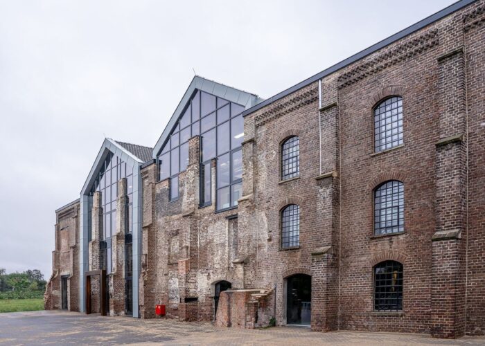 Historic brick industrial building with a modern glass extension